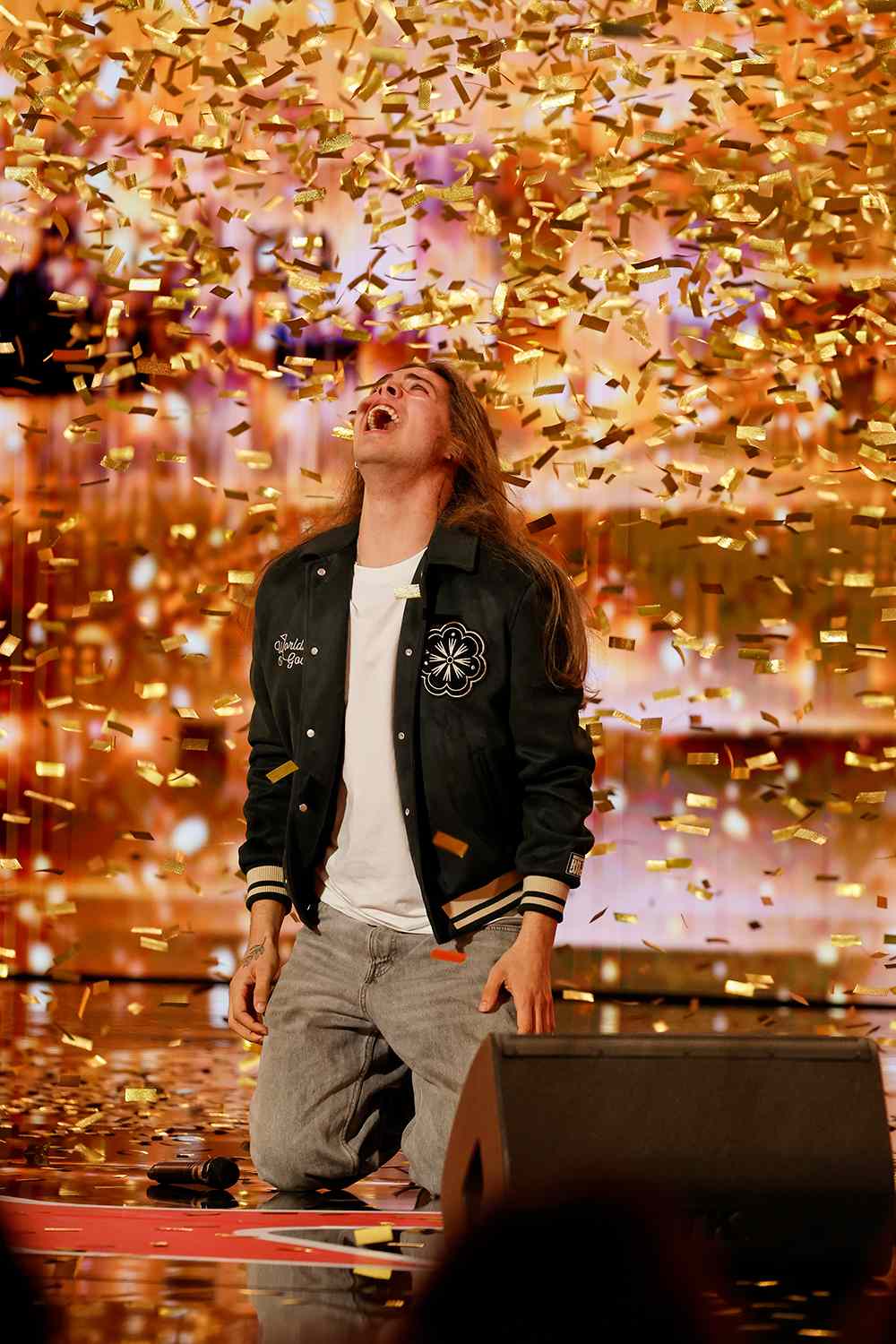Jourdan Blue kneeling in a storm of gold confetti after the Golden Buzzer