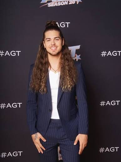 Jourdan Blue on the AGT red carpet in a navy suit