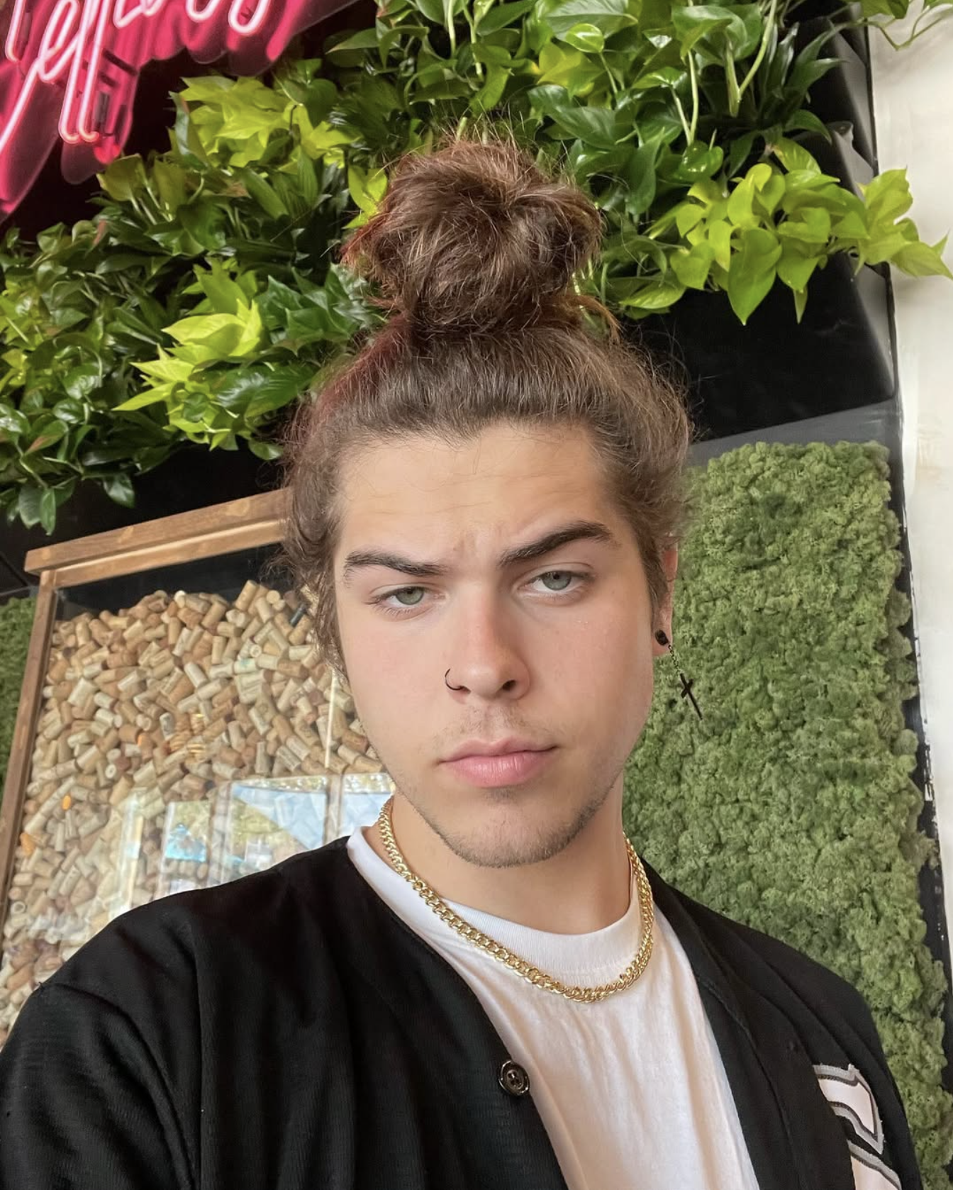 Close-up portrait of Jourdan Blue with a top knot and gold chain